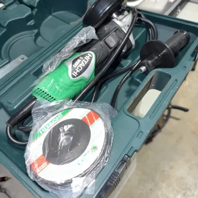 Sale Photo Thumbnail #219: Hitachi G12SR3 corded disc grinder set in green hard carrying case, including side handle and sealed grinding discs.