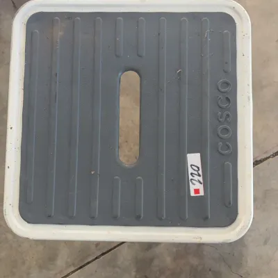 Sale Photo Thumbnail #81: Cosco metal step stool featuring a white frame and a dark gray grooved top step with a center handle opening.