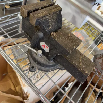 Sale Photo Thumbnail #239: Heavy-duty 4-inch bench vise with a swivel base, showing sawdust and light surface wear.