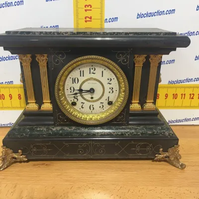 Sale Photo Thumbnail #139: Antique Seth Thomas mantle clock featuring a dark slate case, faux marble accents, ornate gilt metal pillars, and scroll feet.