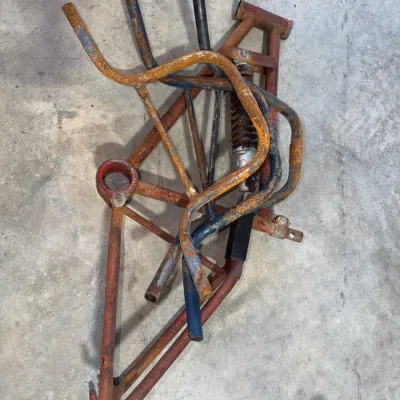 Sale Photo Thumbnail #95: Assorted vintage mini bike and go-kart metal frame components, showing heavy rust and wear.