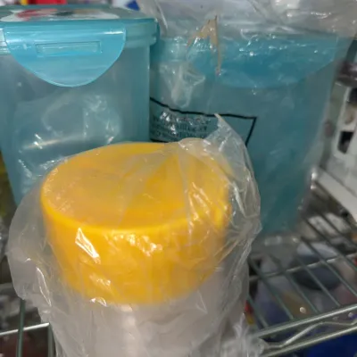 Sale Photo Thumbnail #190: Assorted modern plastic food storage containers, including blue clip-lid containers and a small jar with a yellow lid, partially wrapped in plastic baggies.