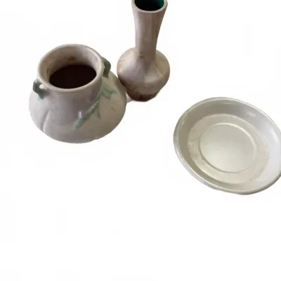 Sale Photo Thumbnail #283: Trio of vintage ceramic items, including an Art Nouveau style double-handled vase with floral detail, a slender necked vase with green interior glaze, and a small round saucer dish.