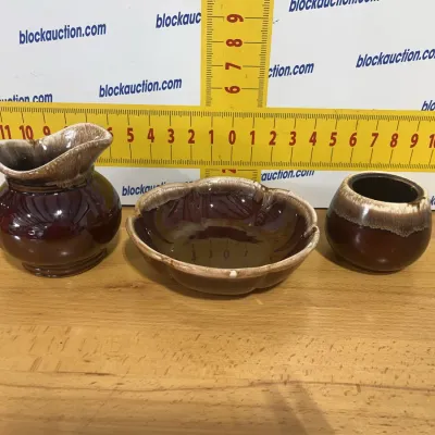Sale Photo Thumbnail #125: Three-piece mid-century Hull Pottery style brown drip glaze ceramic set, including a small pitcher, fluted dish, and rounded pot.