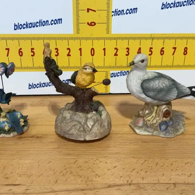 Sale Photo Thumbnail #140: Set of three vintage painted bird figurines, including a bluebird with morning glories, a yellow songbird on a branch, and a seagull perched on a log.