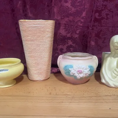 Sale Photo Thumbnail #131: Collection of mid-century pottery items, including a yellow Haeger bowl with original sticker, a tall textured vase, a floral painted planter, and a Madonna planter.
