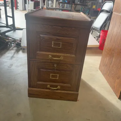 Sale Photo Thumbnail #64: Two-drawer oak filing cabinet featuring brass hardware and label holders, showing minor wear on the finish.
