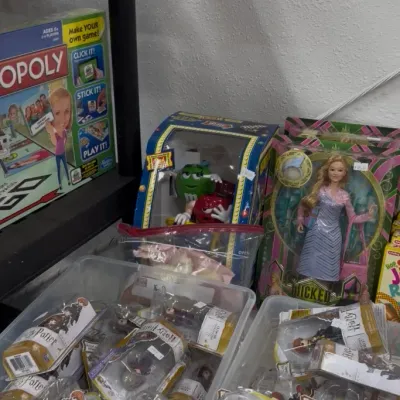 Collection of pop culture toys and board games, featuring boxed Harry Potter collectible figures, a Wicked fashion doll, and an...