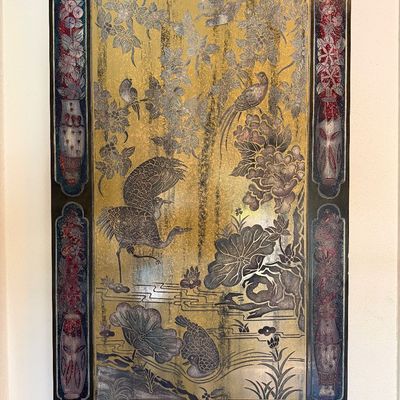 Vintage Asian-style lacquer wall plaque featuring metallic gold and silver tones with carved crane, bird, and floral motifs within a...