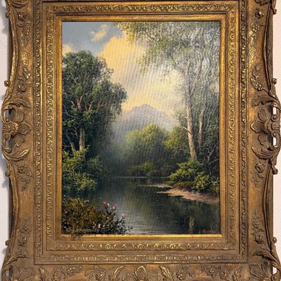 Framed oil painting depicting a tranquil river landscape with lush trees and distant mountains, signed by A. D. Greer. Set in an ornate,...
