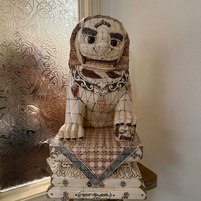 Intricately carved Asian-style mosaic bone guardian lion statue resting on an ornate tiered pedestal, featuring detailed etched and...