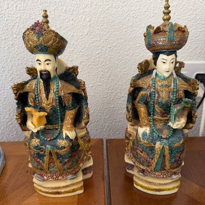 Pair of vintage resin Chinese emperor and empress statues with intricate polychrome painted and gilded detailing.