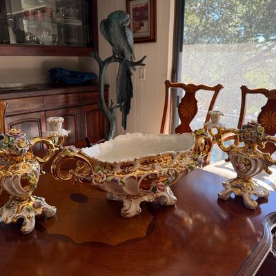 Ornate Capodimonte-style porcelain table set, featuring a footed centerpiece bowl flanked by two matching two-light candelabras with...