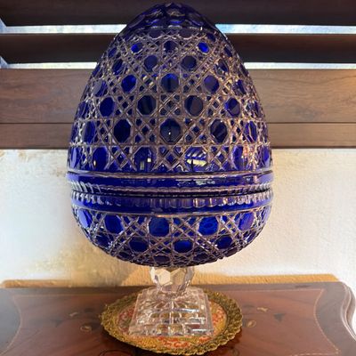 Cobalt blue cut-to-clear crystal egg-shaped urn on a square pedestaled base, featuring intricate geometric lattice patterns.
