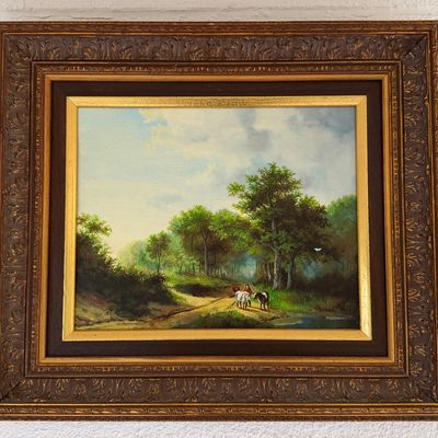 Framed pastoral landscape oil painting depicting a figure tending livestock along a wooded path, housed in an ornate carved wood frame.