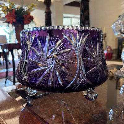 Vintage deep purple cut-to-clear crystal footed bowl featuring intricate pinwheel star patterns and a scalloped rim.