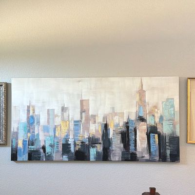 Large contemporary panoramic canvas painting featuring an abstract city skyline with metallic gold and blue accents.