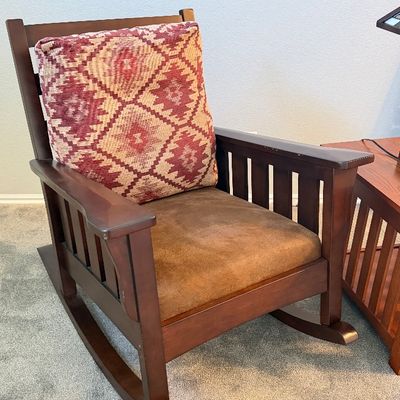 Mission Arts and Crafts style wooden rocking chair with a brown suede seat cushion and a red geometric pattern back pillow.
