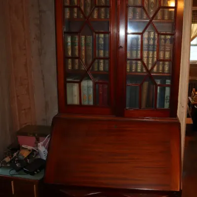 Sale Photo Thumbnail #93: Traditional mahogany slant-front secretary desk featuring a broken pediment bonnet top, glass-paned bookcase cabinet, and serpentine lower drawers.