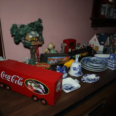 Sale Photo Thumbnail #168: Collection of decorative collectibles, including a red Coca-Cola holiday semi-truck, blue-and-white Delfts-style ceramics, and a miniature treehouse display.