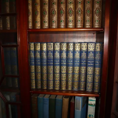 Sale Photo Thumbnail #94: Three shelves of vintage hardback books housed inside a wooden cabinet, including sets of World's Greatest Literature and The Standard American Encyclopedia.