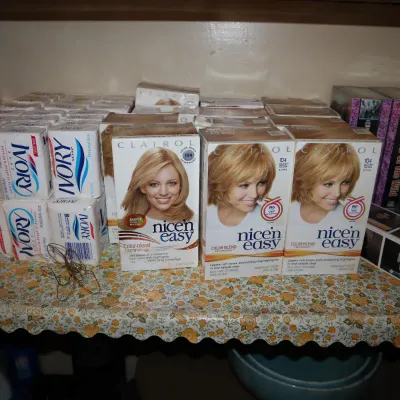 Sale Photo Thumbnail #144: Collection of personal care and household items, including multiple boxes of Ivory soap, Clairol Nice'n Easy hair color, VHS tapes, and office supplies.