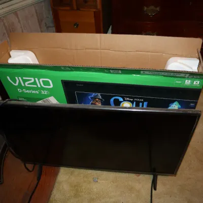 Sale Photo Thumbnail #95: Vizio D-Series 32-inch LED Smart TV sitting in front of its original packaging box.