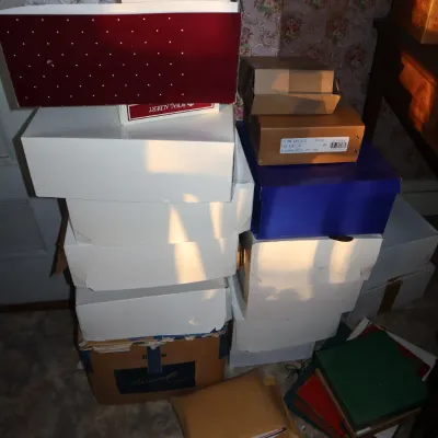 Sale Photo Thumbnail #28: Tall stacks of assorted storage, shoe, and brand boxes, including Royal Albert packaging, containing unexamined household items.