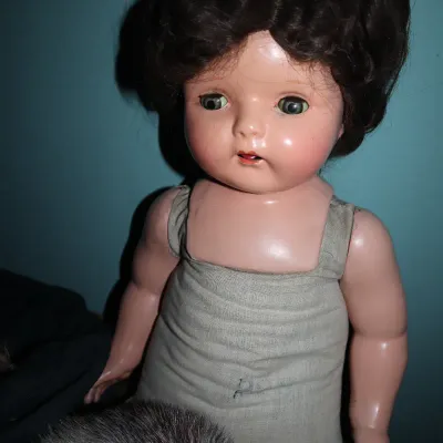 Sale Photo Thumbnail #67: Vintage composition doll featuring dark short hair, green sleep eyes, and a fabric torso undergarment, circa 1930s to 1940s.