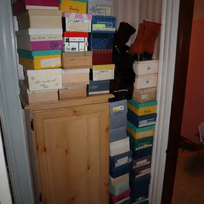 Sale Photo Thumbnail #30: Large collection of vintage shoe boxes stacked high atop a small wooden cabinet and beside it, featuring brands like Connie, Penuljo, and Pierre Debs.