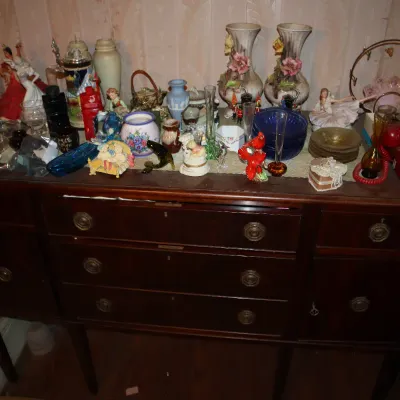 Sale Photo Thumbnail #106: Vintage dark wood sideboard filled with collectibles including porcelain figurines, decorative vases, glassware, and a red push-button telephone.