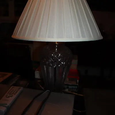 Sale Photo Thumbnail #125: Cut crystal table lamp featuring a diamond-patterned urn-shaped body and a cream pleated fabric shade.