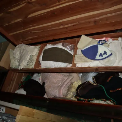 Sale Photo Thumbnail #56: Open vintage cedar-lined hope chest featuring a top sliding tray, filled with various textiles, linens, and clothing items.