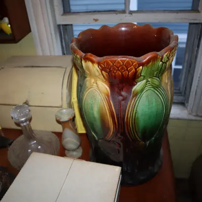 Sale Photo Thumbnail #131: Large Art Nouveau majolica umbrella stand or floor vase, featuring embossed botanical designs with a scalloped rim and rich green and brown glazes.