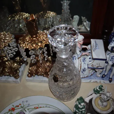 Sale Photo Thumbnail #49: Collection of decorative collectibles, including a pair of gilded brass and crystal prism lamp bases on marble mounts, a cut crystal decanter, and porcelain musical figurines.
