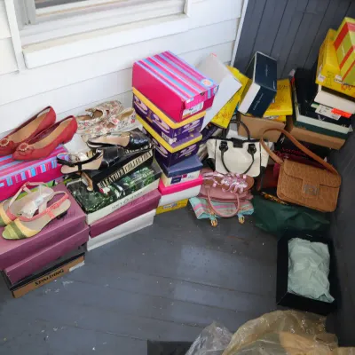 Sale Photo Thumbnail #172: Collection of women's shoes and handbags displayed on and around original shoeboxes on a porch floor.