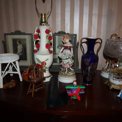 Sale Photo Thumbnail #55: Collection of vintage decor items, including ceramic floral table lamps, a cobalt blue urn vase, framed portraits, and porcelain figurines.
