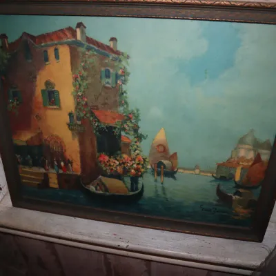 Sale Photo Thumbnail #98: Framed oil painting depicting a Venetian canal scene with gondolas and traditional buildings, set in a dark wood frame.