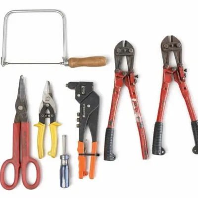 Sale Photo Thumbnail #23: Lot 96: Assorted hand tools including red-handled scissors, tin snips, yellow-handled pliers, a small screwdriver, orange-and-black rivet tool, coping saw, and two pairs of red bolt cutters.