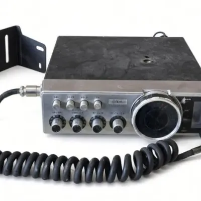 Sale Photo Thumbnail #72: Lot 145: Vintage mobile CB radio transceiver with large channel dial, volume, squelch, RF gain, and delta-tune controls. Includes handheld microphone with coiled cord, mounting bracket, and rear antenna/power connections