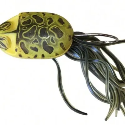 Sale Photo Thumbnail #118: Lot 191: Vintage soft-plastic frog-style fishing lure. Yellow body with black spotted pattern, long trailing plastic legs/tails, and a single hook.