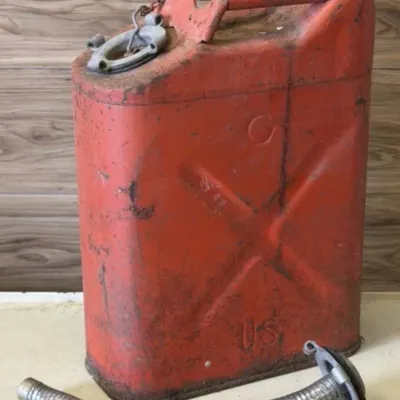 Sale Photo Thumbnail #55: Lot 128: Vintage USMC red metal fuel can (jerrycan style) with flexible metal spout hose. Embossed “U.S.” marking, X-brace design, top handle, and side cap.