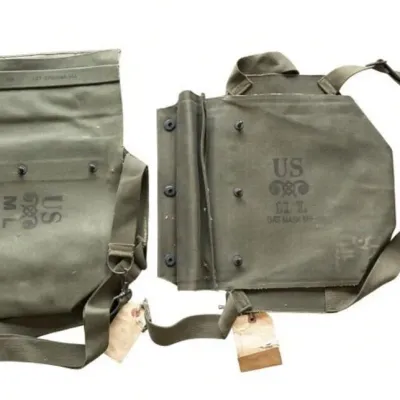 Sale Photo Thumbnail #58: Lot 131: Pair of vintage olive-green canvas U.S. military gas mask carriers (M9). Marked “U.S. M L GAS MASK M9” with webbing straps, metal hardware