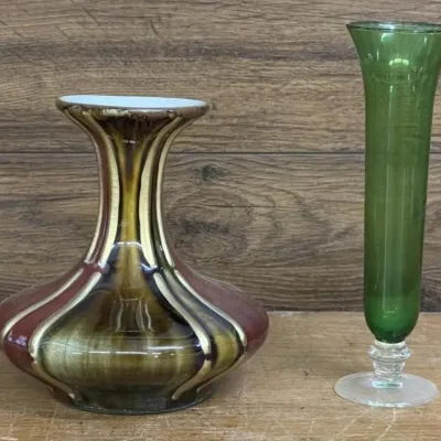 Sale Photo Thumbnail #221: Lot 292: Bulbous ceramic vase & McM vase Two decorative vases. One is a with dripping red, brown, and gold glaze stripes. The other is a tall slender green glass vase with a clear glass foot. Classic mid-century glass and pottery