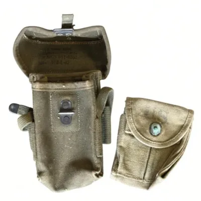 Sale Photo Thumbnail #57: Lot 130: Pair of vintage olive-green canvas military pouches. Larger pouch with metal snap closure and webbing straps; smaller pouch with button/snap flap.