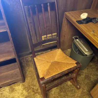Sale Photo Thumbnail #96: Vintage dark stain wooden rocking chair featuring a woven rush seat and a tall spindle back.