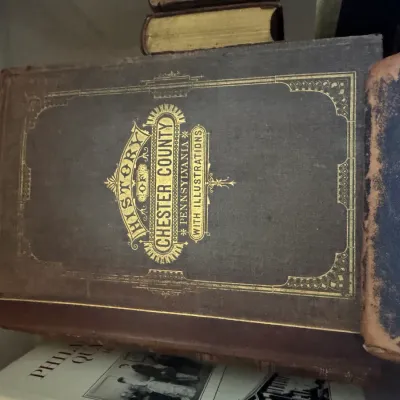 Sale Photo Thumbnail #56: Antique copy of "History of Chester County, Pennsylvania with Illustrations" bound in a dark hard cover with ornate gilt lettering and decorative border details.