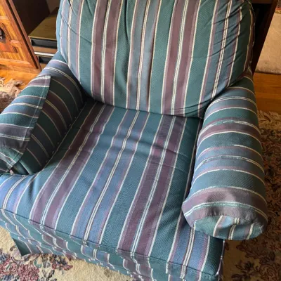 Sale Photo Thumbnail #308: Upholstered armchair featuring a teal, purple, and cream vertical stripe pattern with thick rolled arms and a matching back cushion, circa 1990s.