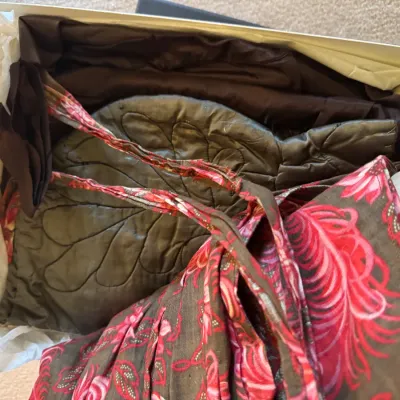 Sale Photo Thumbnail #333: Assorted vintage textiles and garments packed in tissue paper inside a box, including a pink patterned piece and olive quilted fabric.