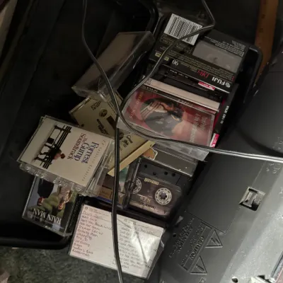 Sale Photo Thumbnail #129: Collection of 1980s and 1990s cassette tapes in a black storage case, featuring movie soundtracks like Forrest Gump and Rain Man alongside home-recorded mixtapes.
